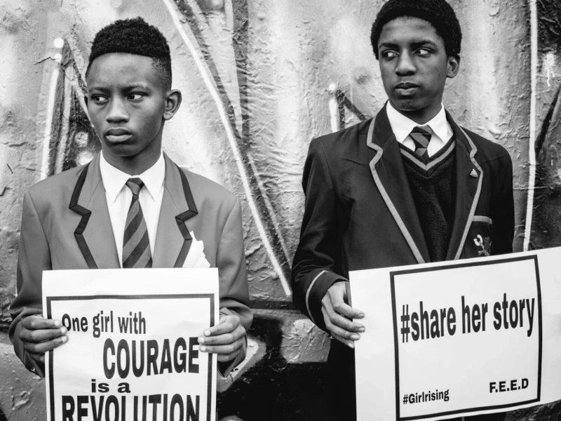 grayscale photography of two men holding banners